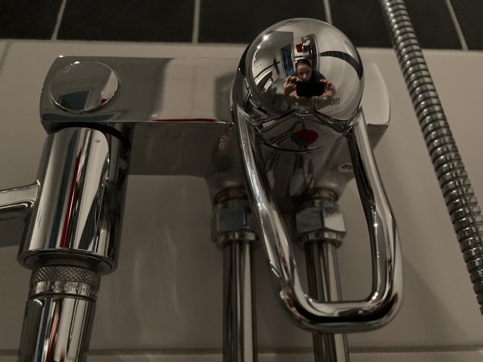 Kromad FM Mattsson-blandare med dropp från vredet, reflekterande yta, på badrumsgolv.