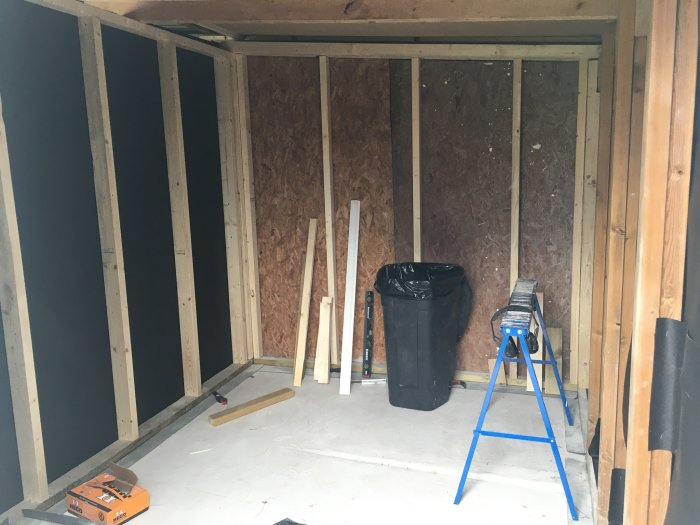 Regelverk för en vägg under konstruktion i ett utrymme med träreglar och OSB-skivor.
