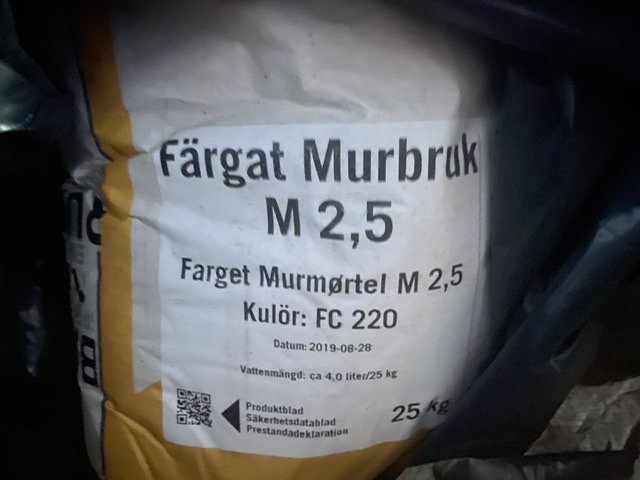 Säck av färgat murbruk M 2,5 med specifierad vattenmängd och färgkod FC 220, datumstämpel synlig.