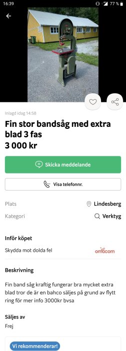 En stor bandsåg utomhus framför en gul byggnad, till salu med extra blad, 3-fas.