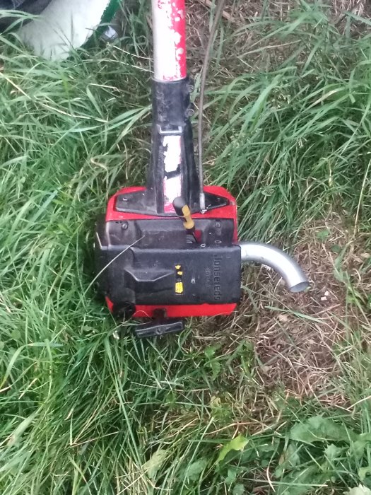 Nedsliten röjsåg liggande i gräset.