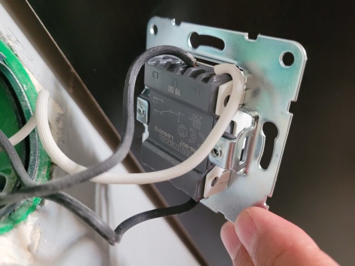 Installationsprocess av eluttag med exponerad elledningar och eldosor.
