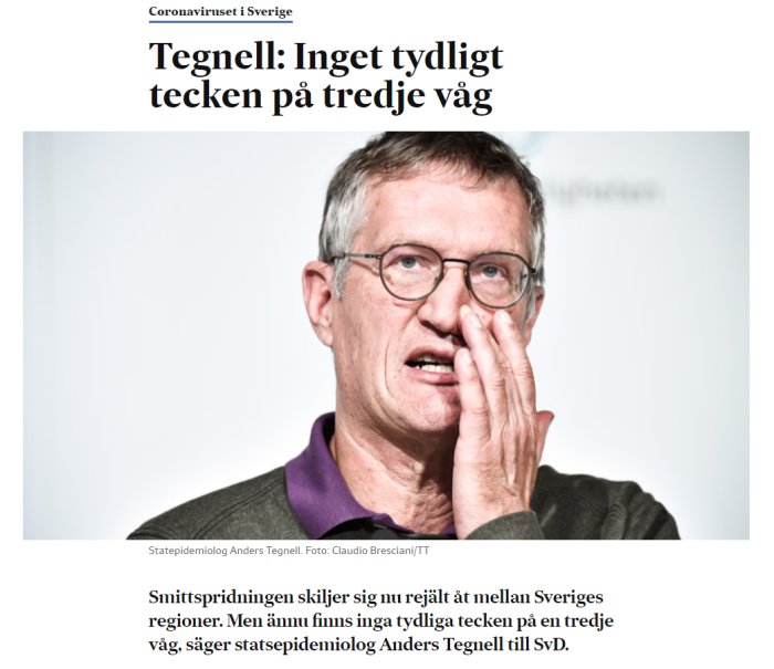 Man i profil ser bekymrad ut och rör vid sitt ansikte mot en oskarp vit bakgrund.