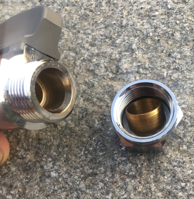 Ventil och klämringskoppling på granityta med fokus på gängade anslutningar.