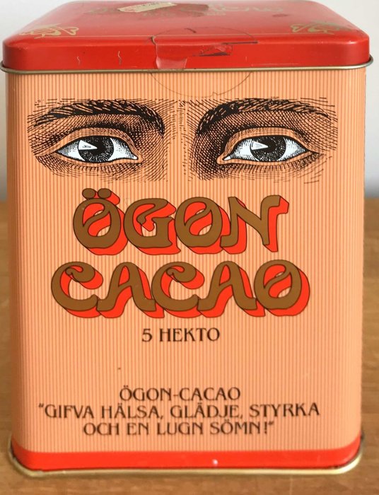 Gammal kakaoburk med ögonillustration och texten "Ögon Cacao" i rött på en randig bakgrund.