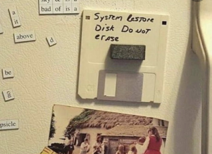 Diskett uppmärkt "System Restore Disk Do not erase" på en anslagstavla med magnet.