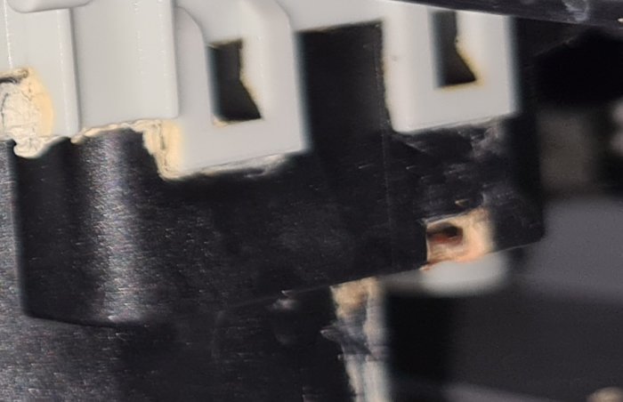 Närbild på en spolarmsväxlare med en misstänkt spricka i plasten intill ett vitt snäppe.