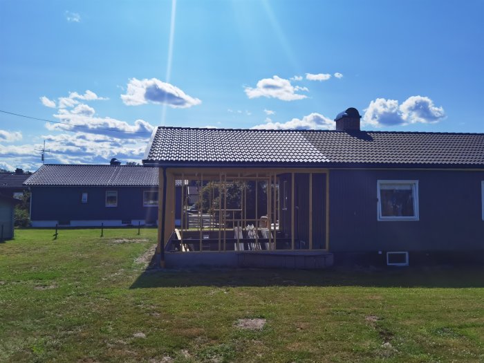 Ett nyligen renoverat hus med nytt tak och takavvattning under en klarblå himmel.