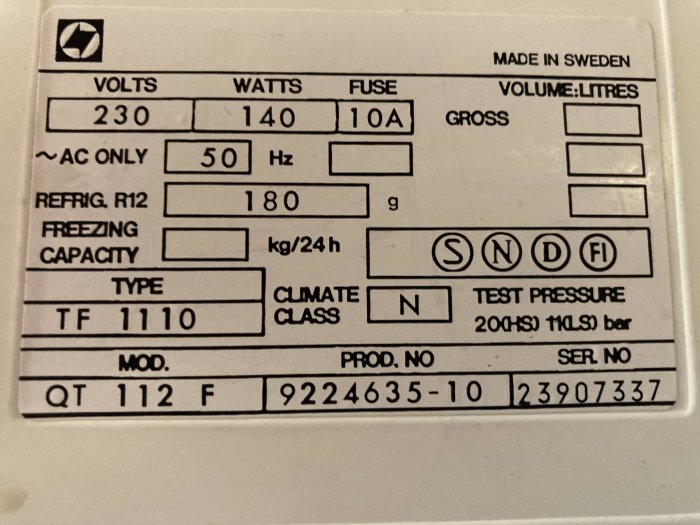 Bild på ett typskylt i ett gammalt frysskåp med tekniska specifikationer och serienummer.
