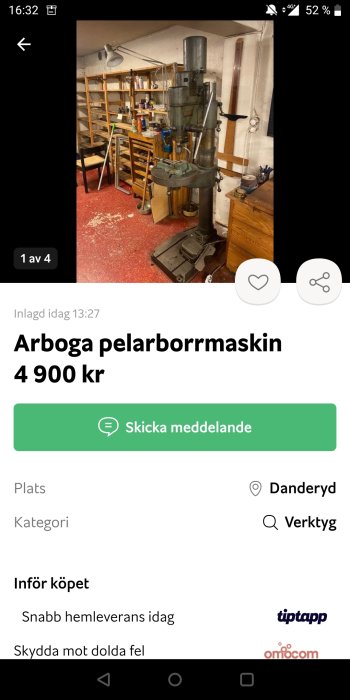 En begagnad Arboga pelarborrmaskin i ett verkstadsrum med verktyg och hyllor i bakgrunden.