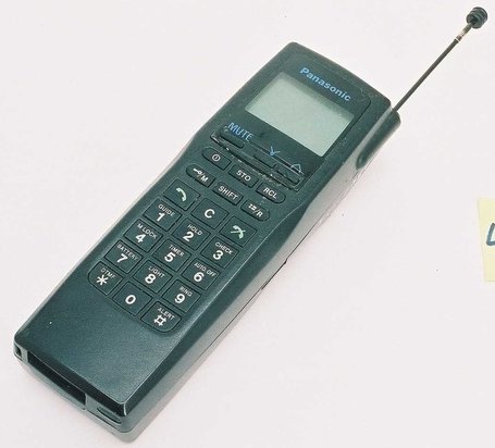 Äldre Panasonic model I bärbar telefon med utdragen antenn och numeriskt tangentbord.