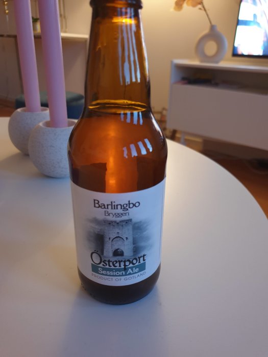 Ölflaska från Barlingbo Bryggeri, Österport Session Ale, på ett bord med suddig bakgrund.
