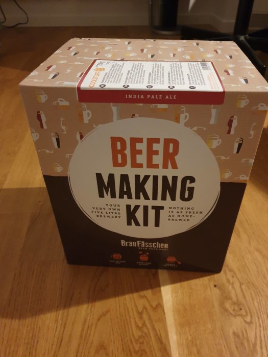 Öl-bryggningskit för hemmabruk för India Pale Ale, står på ett trägolv.