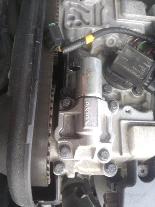 Motor av Volvo V70 med synlig kamaxelsolenoid och elektrisk anslutning.