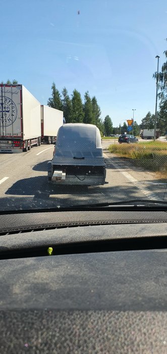 Bild från bilens insida visar ett släp utan surrning på en vägkorsning.