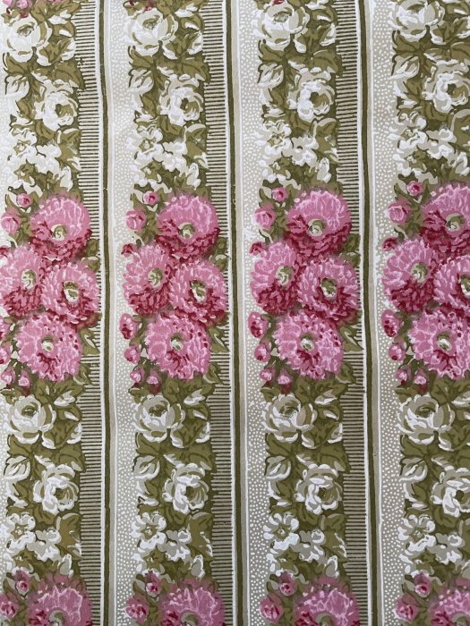 Gammaldags tapetmönster med rader av rosa och vita blommor på en ljus bakgrund.