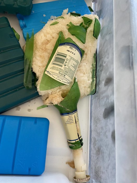 Fryst blomkålshuvud med etikett i frysfack bredvid kylklampar och hackad blomkål.