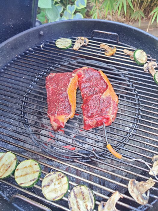 Råa biffar med paprika och grillade grönsaker på en kolgrill.