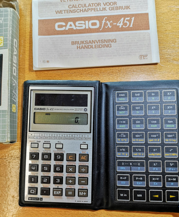 Casio FX-451 vetenskaplig miniräknare med öppen bruksanvisning.