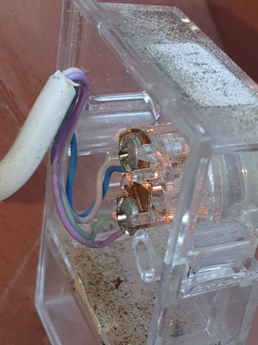 Närbild på en gammal trafo med kopplade kablar och tecken på användning.