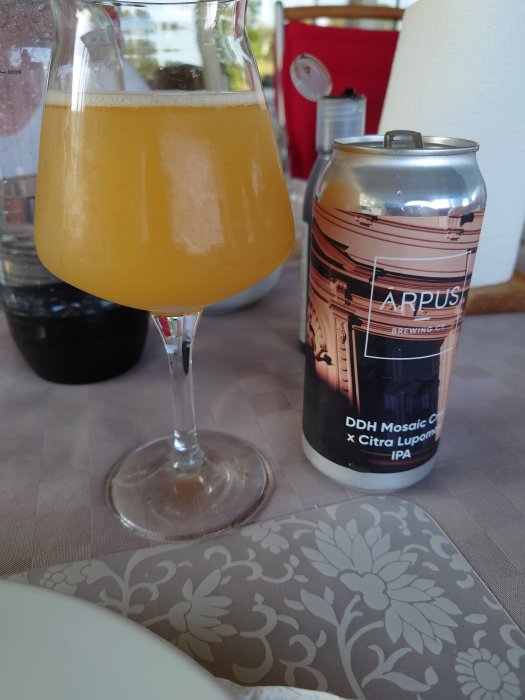 En burk Arpus Brewing IPA och ett glas grumlig öl på ett bord med frukostservett.