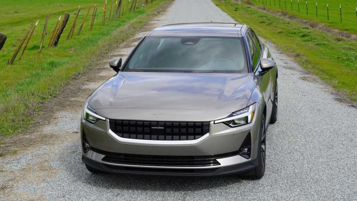 Polestar 2 elbil parkerad på en grusväg med landskap i bakgrunden.