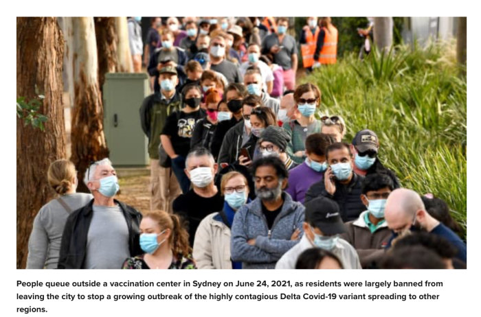 Folk i lång kö utanför vaccinationscenter i Sydney med munskydd, tätt ihop under pandemin.
