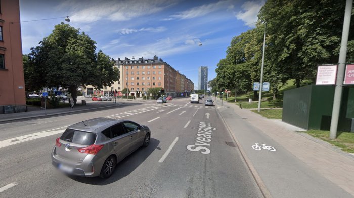 Stadsgata med markerad cykelbana och mötande fordonstrafik.