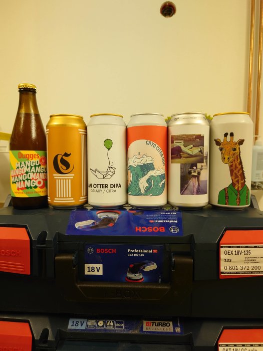 Samling ölburkar med unik design på verktygslåda, Bosch batteri framför.