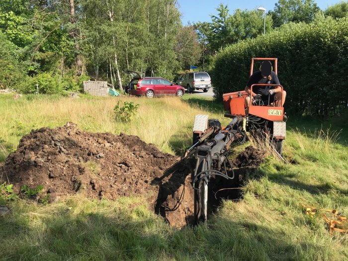 Person använder en grävmaskin för att gräva i lerjorden på en byggarbetsplats.