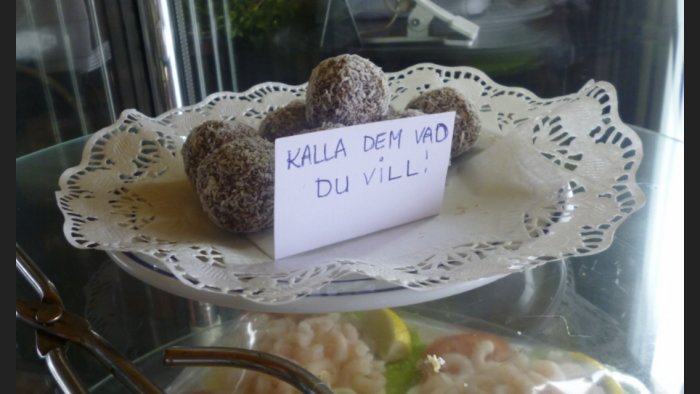 Chokladbollar på fat med ett skyltkort som har texten "Kalla dem vad du vill!