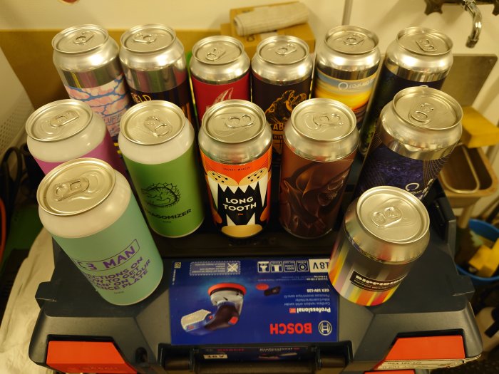 Olka burkar med olika färgglada etiketter upplagda på en verktygslåda.