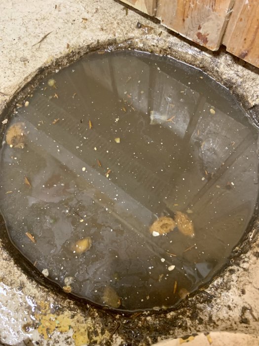 Vattenansamling på ett bygge där stillastående vatten samlats i en fördjupning i betonggolvet.