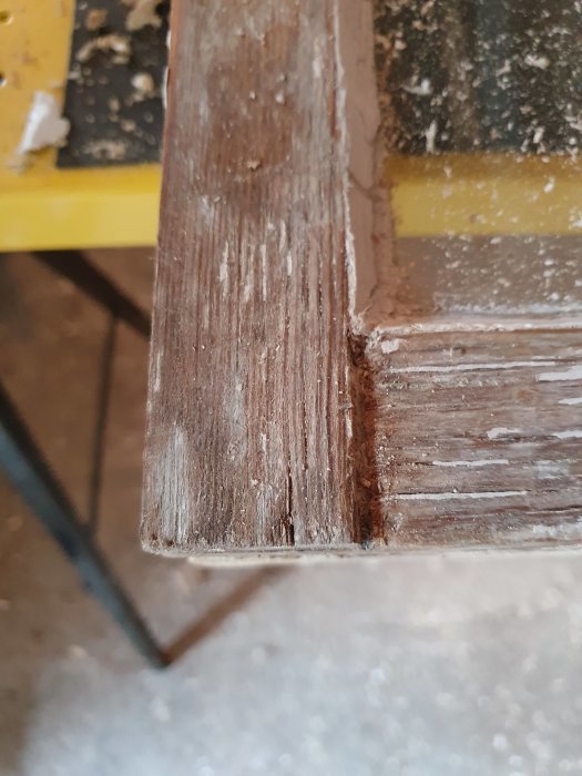 Närbild av ett gammalt fönsterträ som slagit sig och visar sprickor.