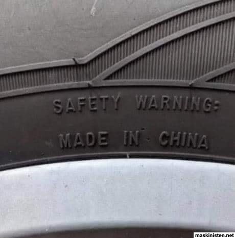 Däckdetalj med texten "SAFETY WARNING: MADE IN CHINA" ingraverat på gummioverflaten.