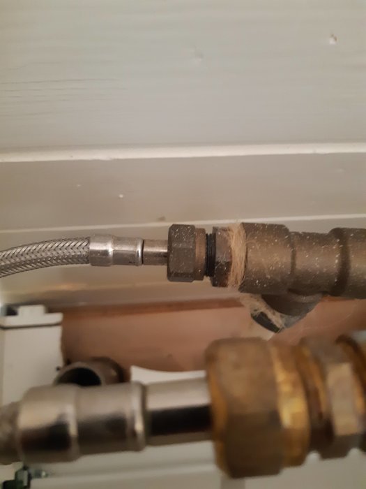 Närbild av befintlig vattenblandarkoppling med förnicklade delar och fråga om kompatibilitet.