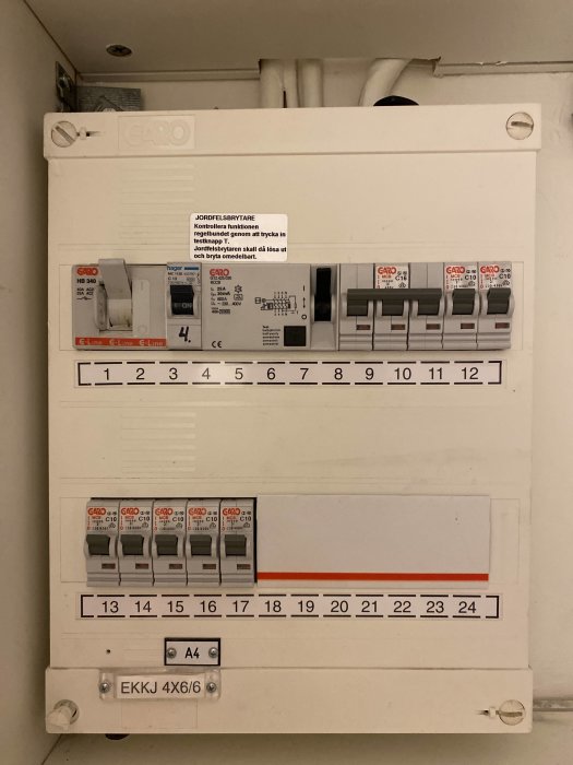 Elskåp öppet med säkringar och automater i ett hem, etiketter och numrerade platser synliga.