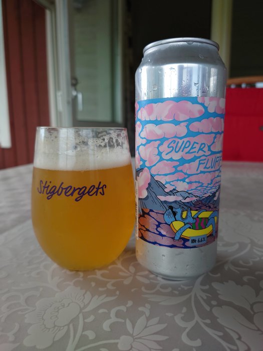 Ölglas märkt 'Stigbergets' och burk 'Super Fluffy' på ett bord, daggiga efter kylningsprocess.