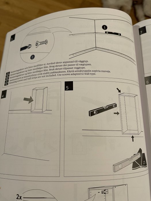 Monteringsinstruktioner för köksskåp med betoning på väggfästen och användning av rätt skruvtyper.