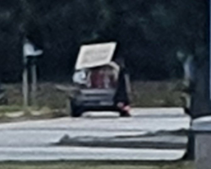 Suuddig bild av en överlastad bil med spännband och diverse material.
