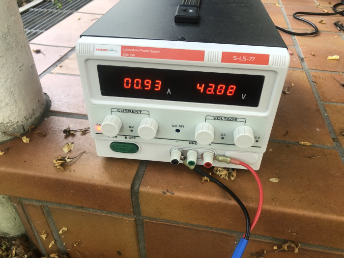 Laboratorieströmförsörjning med digitala avläsningar visar 0.093A och 42.88V under mätning utomhus.