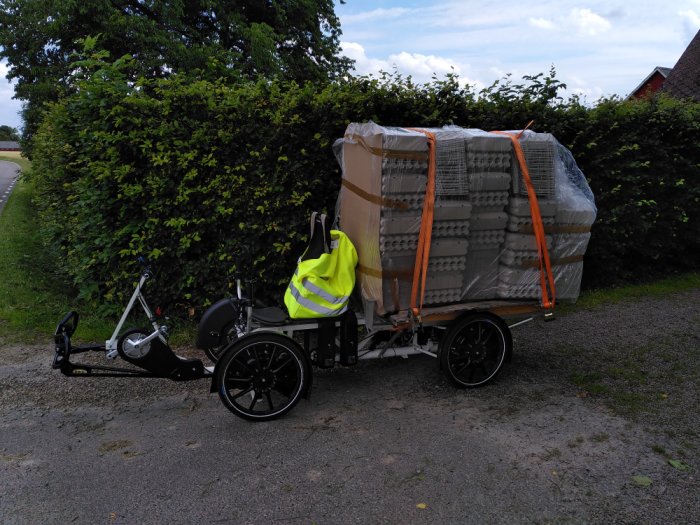 Velove Armadillo el-lastcykel fullastad med äggkartonger, säkrad med spännband.