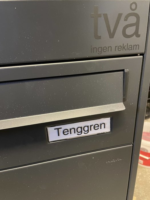 Nyligen applicerade dekaler på en brevlåda med texten "två ingen reklam" och namnet "Tenggren".