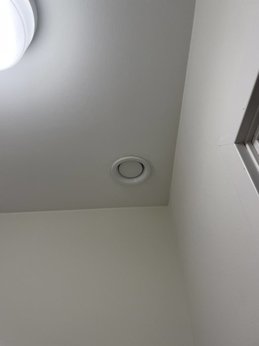 Spotlight och ventilation i taket av en WC som kan behöva justeras vid sänkning av innertak.