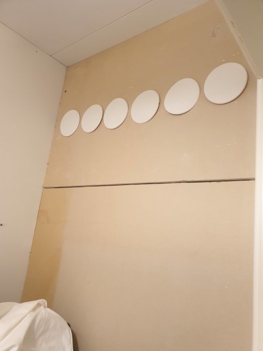 Sovrumsförråd med sex vita ventilationsplattor på väggen.