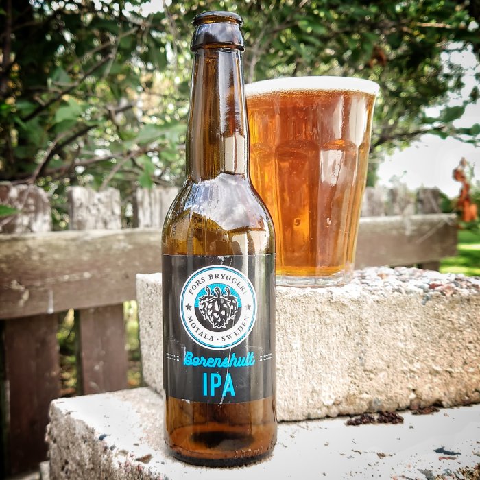 Flaska och glas med IPA-öl utomhus, Borens Hult Bryggeri, etikett synlig.
