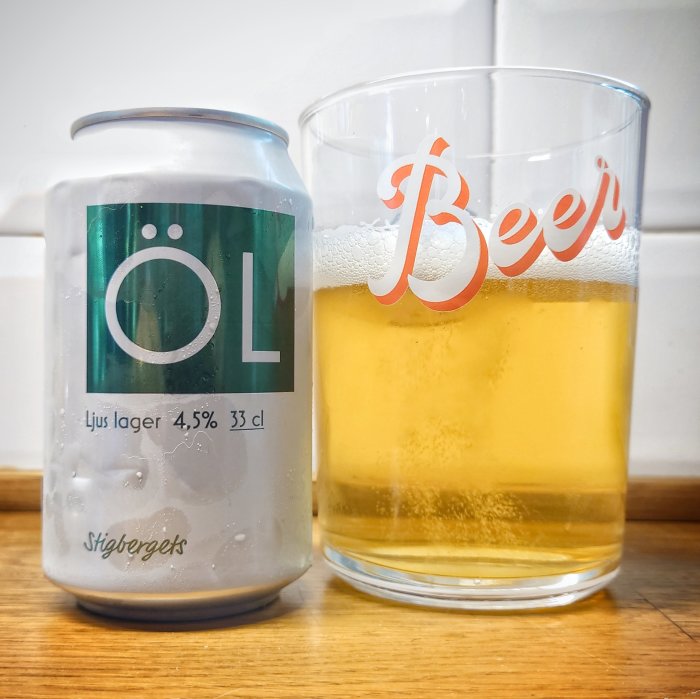 Ölburk bredvid ett glas halvfullt med lageröl, ölet ser uppfriskande ut mot vita köksplattor.