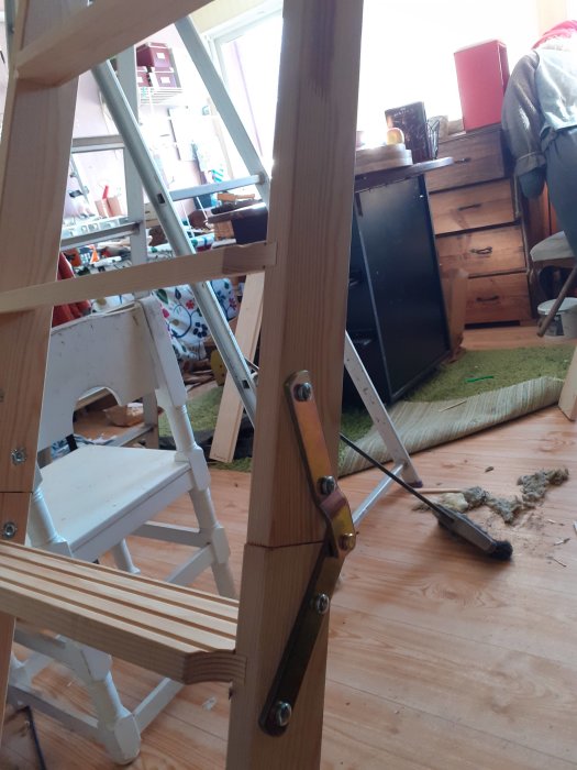 Nybyggd trästege som ser ut att vika sig med inredningsdetaljer i bakgrunden.