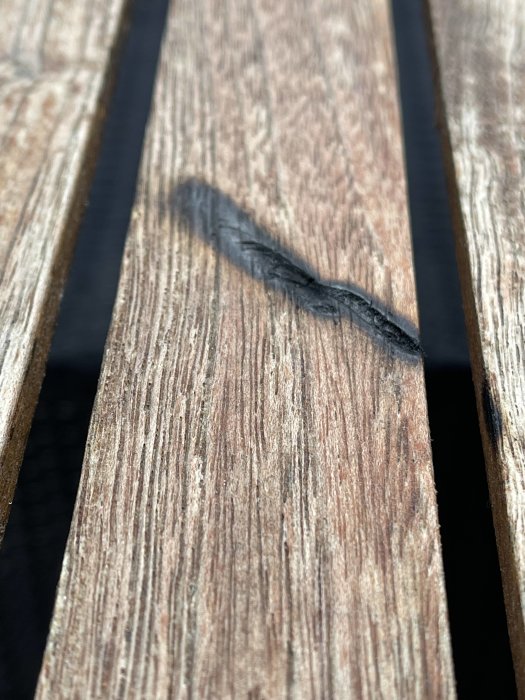 Brandskada på teakbord med 3-5 mm djupt svedd fläck på träytan.