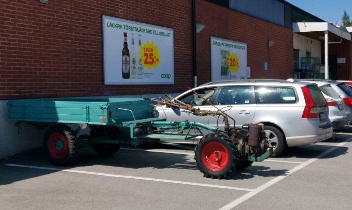 En IRUS universalmotor med släpvagn parkerad utanför en affär.